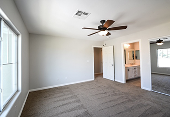 Spacious remodeled living room in Pacoima with new carpeting and modern lighting.